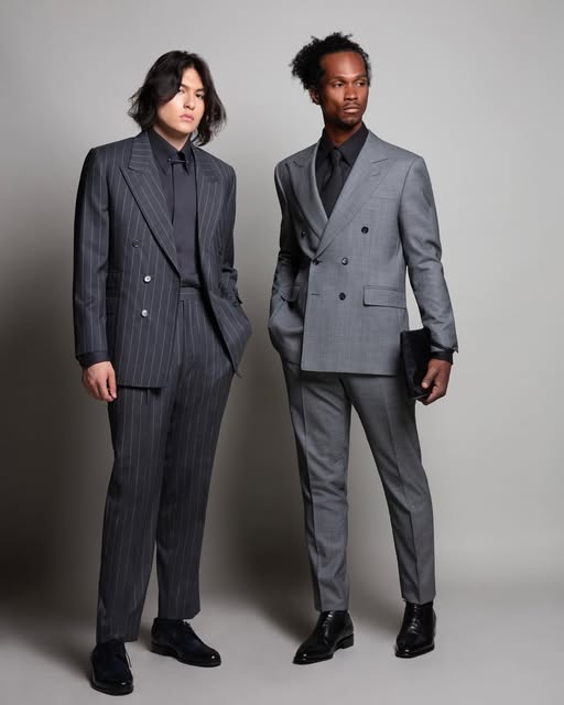 Two models in coordinated charcoal and grey tailored suits